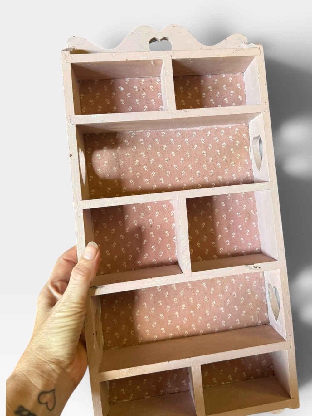 Vintage pink wooden shelf with heart cutouts